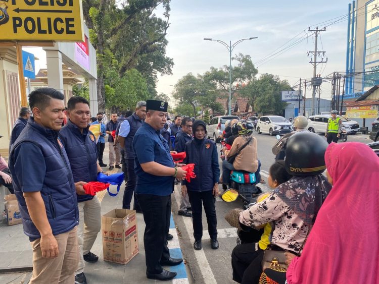 Direktur Reserse Narkoba Kombes Pol. Dewa Made Palguna membagikan takjil kepada pengendara di depan Mapolda Jambi, Selasa (10/3/2026). (Dok. Nahar)