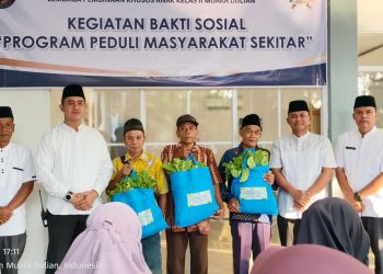 Kepala LPKA Kelas II Muara Bulian J. Kasogi Surya Fattah bersama jajaran pegawai menyerahkan paket sembako kepada warga saat kegiatan bakti sosial “IMIPAS Peduli Masyarakat Sekitar” di Muara Bulian, Jumat (13/3/2026). (Dok. Humas)
