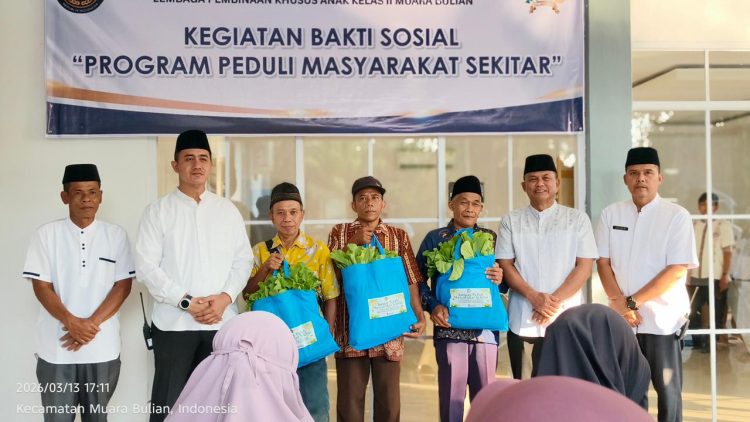 Kepala LPKA Kelas II Muara Bulian J. Kasogi Surya Fattah bersama jajaran pegawai menyerahkan paket sembako kepada warga saat kegiatan bakti sosial “IMIPAS Peduli Masyarakat Sekitar” di Muara Bulian, Jumat (13/3/2026). (Dok. Humas)
