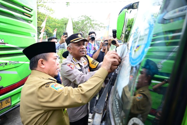 Gubernur Al Haris menempelkan stiker di kendaraan saat pelepasan peserta mudik gratis dalam rangka pencanangan Angkutan Lebaran Terpadu 2026 di Terminal Tipe A Alam Barajo, Sabtu (14/3/2026). (Dok. Nahar)