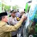 Gubernur Al Haris menempelkan stiker di kendaraan saat pelepasan peserta mudik gratis dalam rangka pencanangan Angkutan Lebaran Terpadu 2026 di Terminal Tipe A Alam Barajo, Sabtu (14/3/2026). (Dok. Nahar)