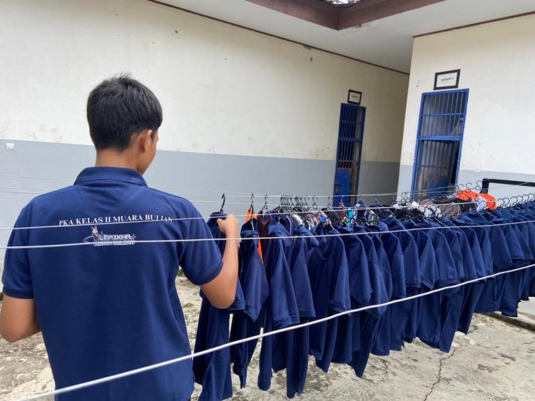 Seorang anak binaan di LPKA Muara Bulian menata pakaian hasil program laundry gratis di lingkungan lembaga, Kamis (26/3/2026) (Dok. Humas)