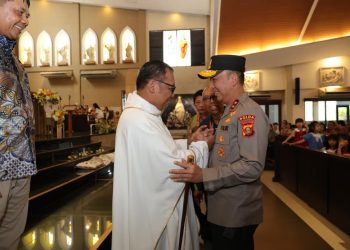 Kapolda Sumatera Selatan Irjen Pol Sandi Nugroho menyapa dan berjabat tangan dengan romo usai misa Paskah di Gereja Santo Yoseph Palembang, (Dok  Humas)