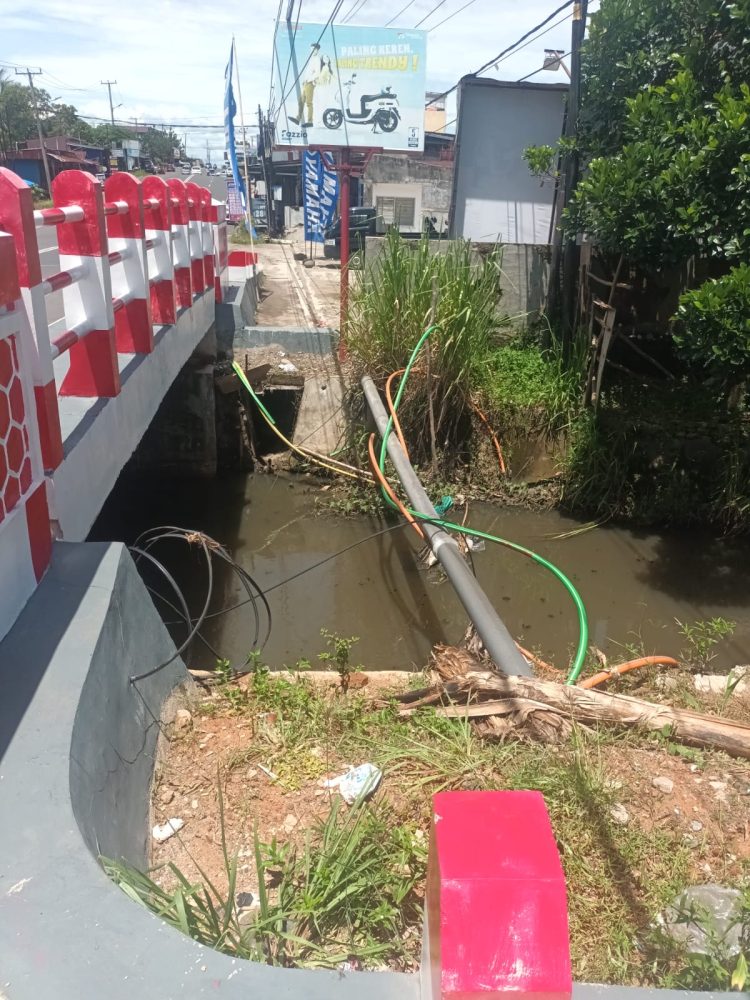 Kabel jaringan milik Telkom Indonesia menjuntai dan semrawut di Jembatan Air Cugung Patil. (Foto:Yl)