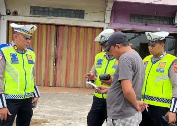 Anggota Ditlantas Polda Jambi melakukan penindakan pelanggaran lalu lintas menggunakan perangkat ETLE Handheld dalam patroli di Kota Jambi, Selasa (14/4/2026). (Dok. Nahar)