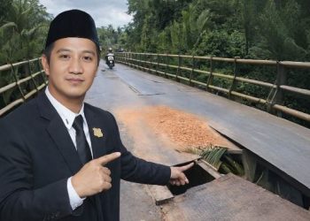 Anggota DPRD Tanjung Jabung Barat Hery Saputra menunjukkan kondisi kerusakan Jembatan Harmoko di Kecamatan Bram Itam (Dok. Daus)