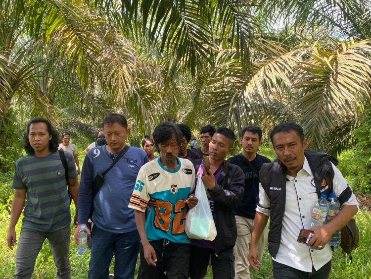 Petugas kepolisian bersama warga mengevakuasi seorang anggota Suku Anak Dalam (SAD) yang sebelumnya dilaporkan hilang usai bentrokan di kawasan PT Sari Aditya Loka (SAL), (Dok. Humas)