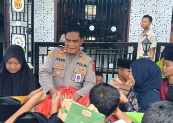 Kapolsek Pauh IPTU Hans Simangunsong membagikan bantuan kepada masyarakat saat pelaksanaan program Jumat Barokah di Masjid Al-Kautsar, Kelurahan Pauh, Kabupaten Sarolangun, Jumat (17/4/2026). (Dok. Humas)