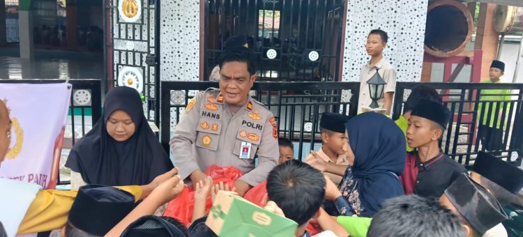 Kapolsek Pauh IPTU Hans Simangunsong membagikan bantuan kepada masyarakat saat pelaksanaan program Jumat Barokah di Masjid Al-Kautsar, Kelurahan Pauh, Kabupaten Sarolangun, Jumat (17/4/2026). (Dok. Humas)